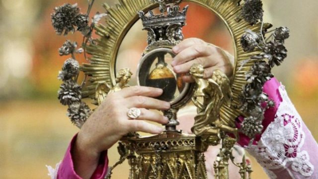 A cardinal holds up the vials containing the liquefied blood of St. Januarius before the congregation in Naples Cathedral