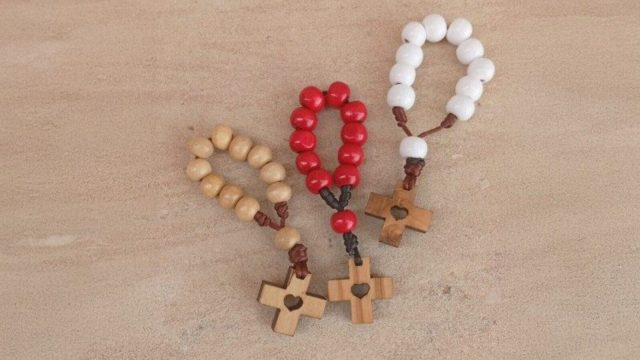 Children holding rosaries as they pray together