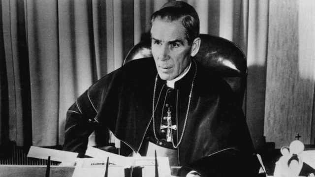 Fulton Sheen wearing a bishop's cape and pectoral cross