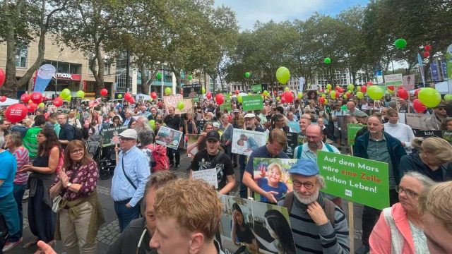 Marchers carrying banners and pro-life placards through a European city street during a March for Life