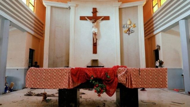 The ruins of a destroyed church in Nigeria, with collapsed walls and a roofless interior
