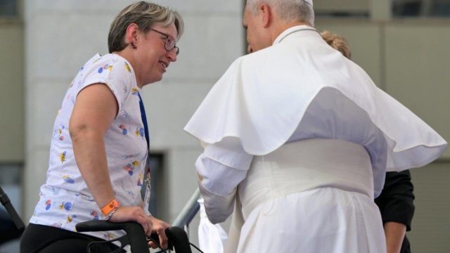 Pope Leo XIV leaning toward sick pilgrims in wheelchairs at the shrine in Lourdes