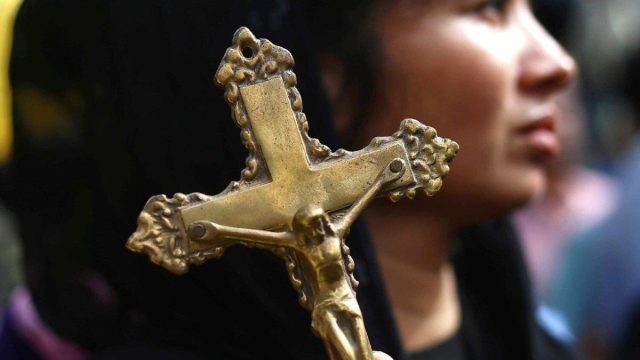 A Pakistani Christian holds a cross during a gathering calling for protection of religious minorities