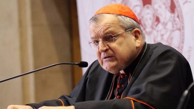 Cardinal Raymond Burke speaking at a lectern during the Marian symposium in Rome