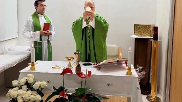 Pope Leo XIV in green liturgical vestments celebrating Mass in a room at the Gemelli hospital in Rome, with hospital staff attending