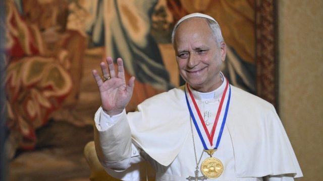 Pope Leo XIV waving as he boards a papal plane