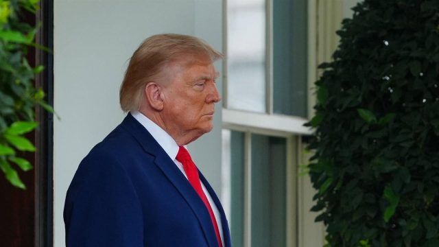 President Donald Trump speaking at a microphone